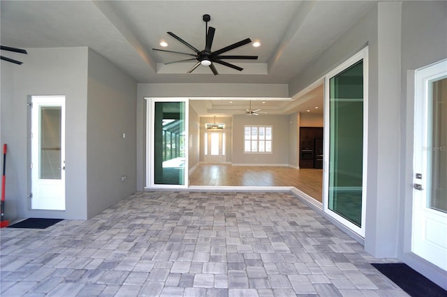 interior space with a tray ceiling and ceiling fan