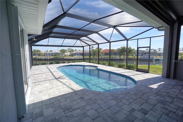 view of swimming pool featuring a patio area, glass enclosure, and a water view