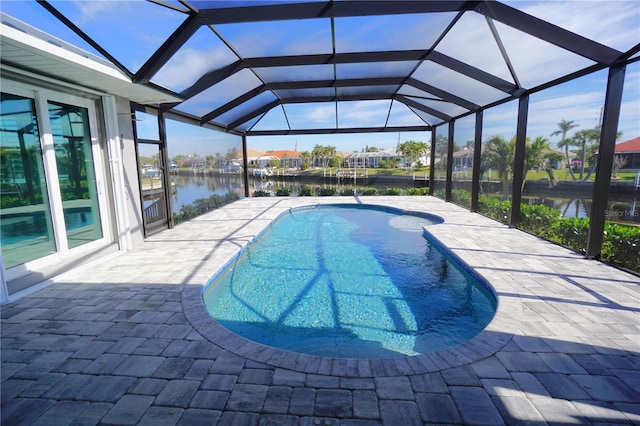 view of swimming pool with a patio, a water view, and glass enclosure