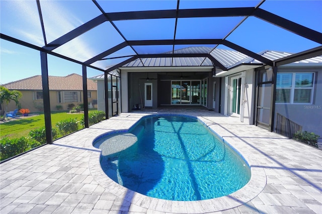 view of pool with ceiling fan, a patio area, and glass enclosure