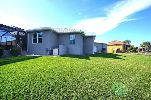 rear view of property with a yard and a lanai