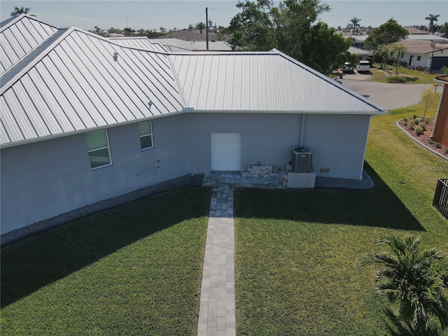 view of side of home featuring a yard and central AC unit