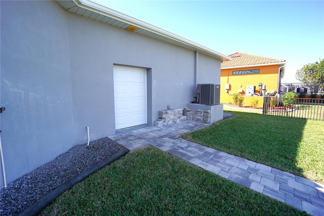 view of yard with a garage and central air condition unit