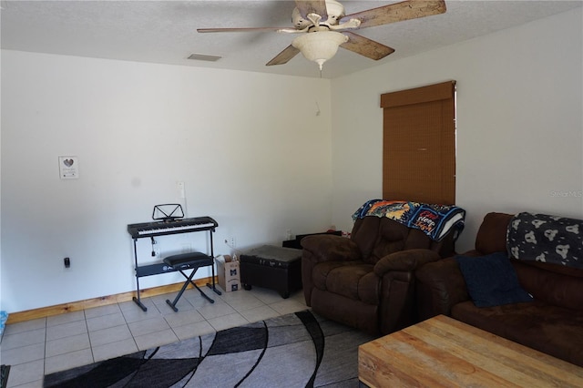 living room with ceiling fan, light tile patterned floors, and a textured ceiling