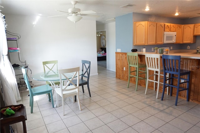 dining space with ceiling fan and light tile patterned floors