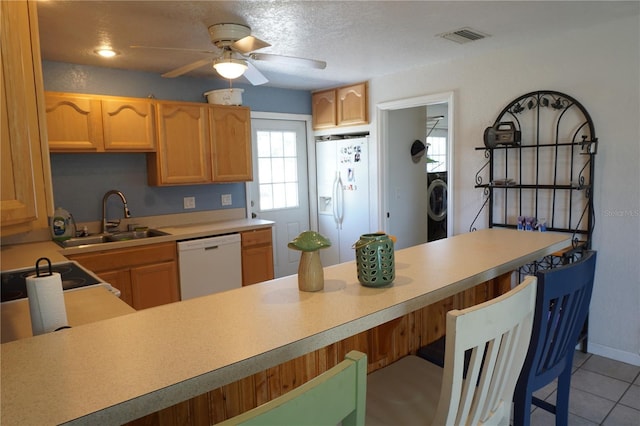 kitchen featuring light tile patterned flooring, washer / dryer, sink, ceiling fan, and white appliances