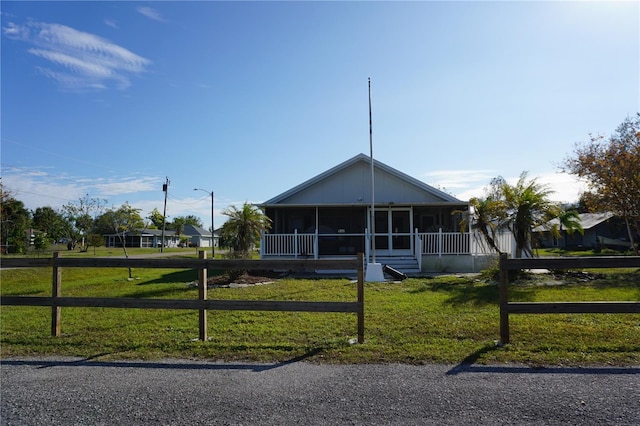 view of front of home featuring a front lawn and a sunroom