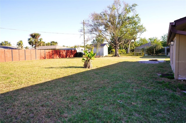 view of yard with an outdoor fire pit and a storage shed