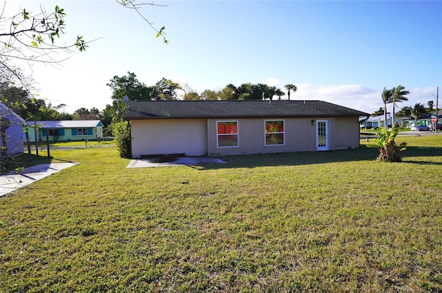 rear view of property with a yard