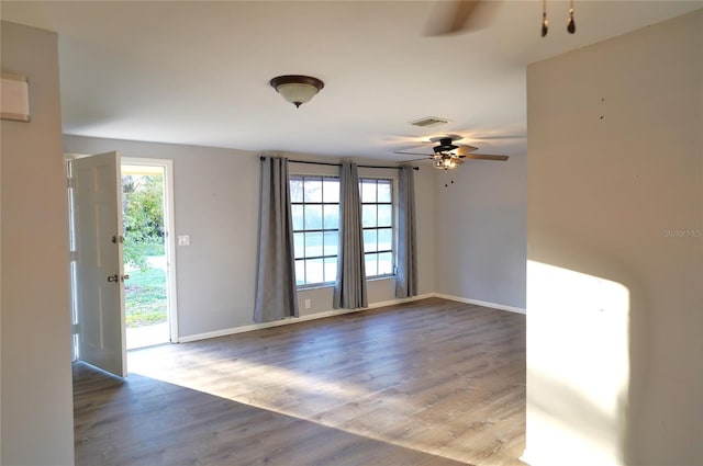 empty room with hardwood / wood-style floors and ceiling fan