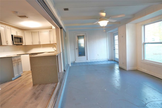 kitchen with white cabinetry, sink, decorative backsplash, and ceiling fan