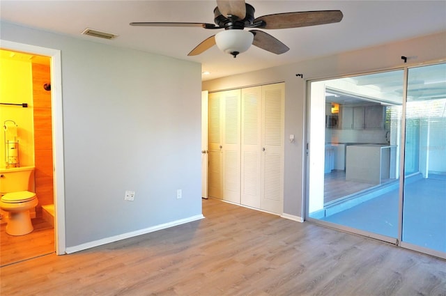 unfurnished bedroom with light hardwood / wood-style flooring, ceiling fan, connected bathroom, access to outside, and a closet