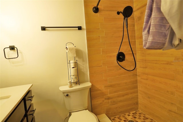 bathroom featuring vanity, tiled shower, and toilet