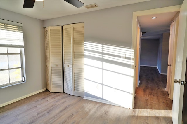 unfurnished bedroom with ceiling fan, light hardwood / wood-style floors, and a closet