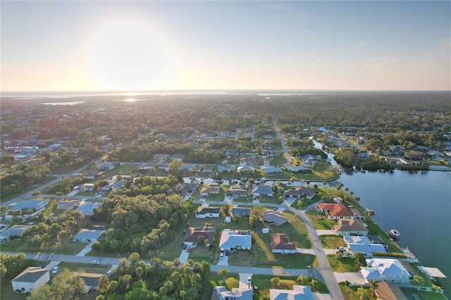 aerial view at dusk featuring a water view