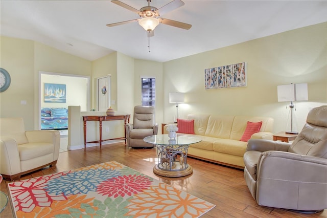 living room featuring lofted ceiling, ceiling fan, and light hardwood / wood-style flooring