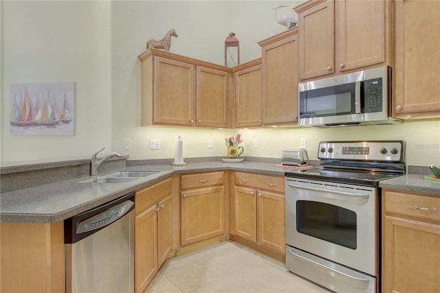 kitchen featuring stainless steel appliances, sink, light brown cabinets, and light tile patterned floors