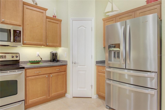 kitchen featuring stainless steel appliances and light brown cabinets