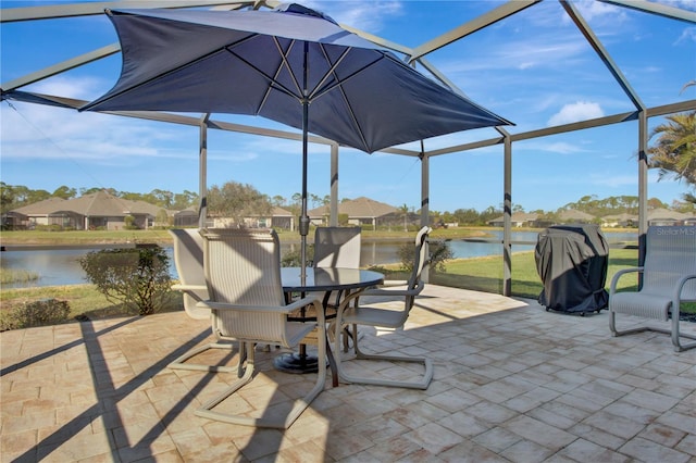 view of patio featuring a water view and glass enclosure