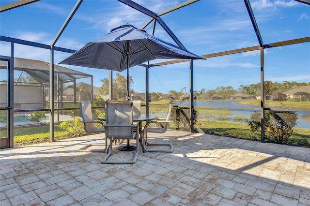 view of patio / terrace featuring a water view and glass enclosure