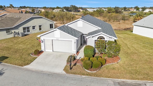 view of front of property featuring cooling unit, a garage, and a front yard