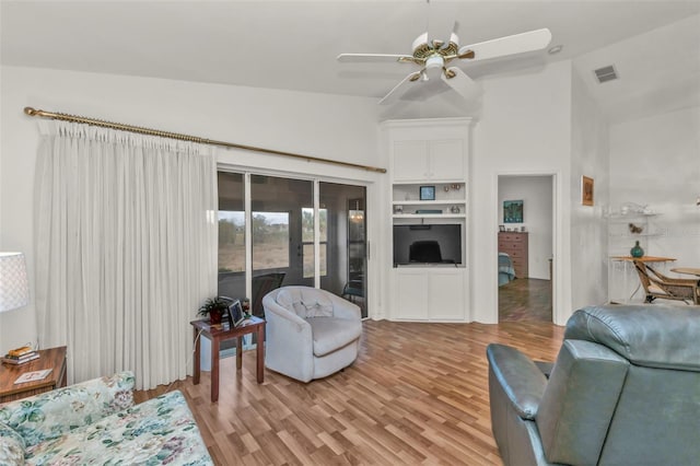 living room featuring high vaulted ceiling, ceiling fan, and light wood-type flooring