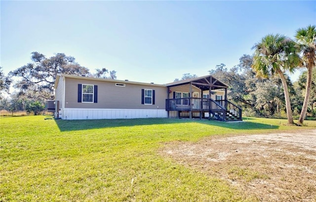 back of house with a lawn and a deck