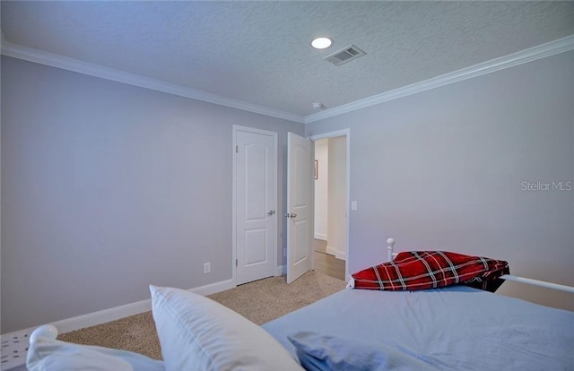 carpeted bedroom featuring crown molding and a textured ceiling