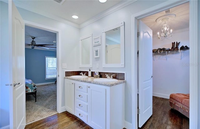 bathroom with ceiling fan, ornamental molding, wood-type flooring, and vanity