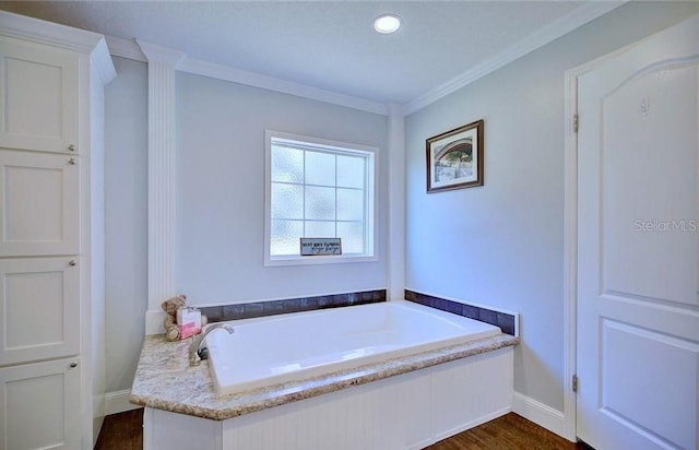 bathroom featuring ornamental molding, wood-type flooring, and a bathtub