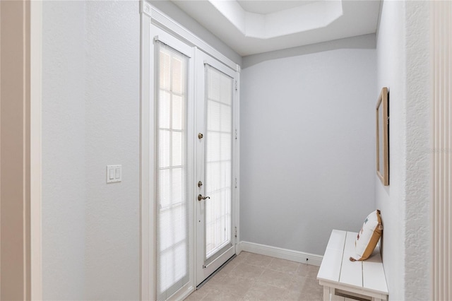 doorway featuring french doors, plenty of natural light, and a tray ceiling