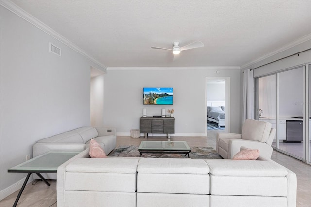 living room featuring ceiling fan, ornamental molding, a textured ceiling, and light tile patterned floors