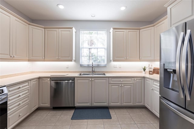 kitchen with appliances with stainless steel finishes, sink, and light tile patterned floors