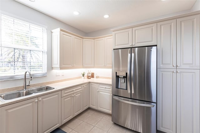 kitchen with sink, light tile patterned floors, and stainless steel fridge