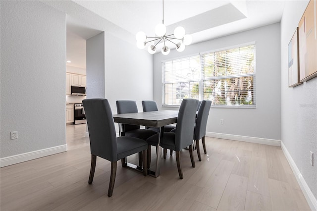 dining area with an inviting chandelier and light hardwood / wood-style floors