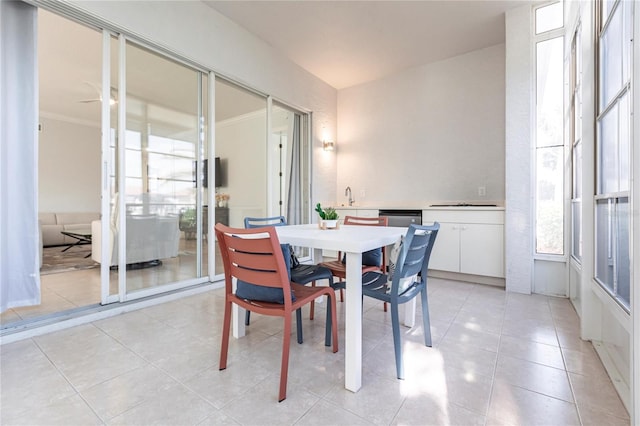 dining space with ornamental molding, sink, and light tile patterned floors