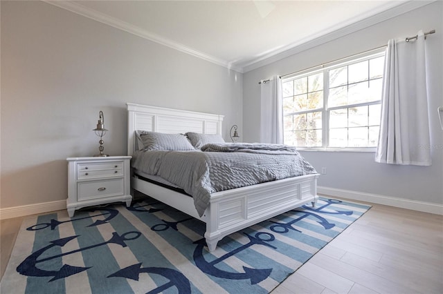 bedroom featuring ornamental molding and light hardwood / wood-style flooring