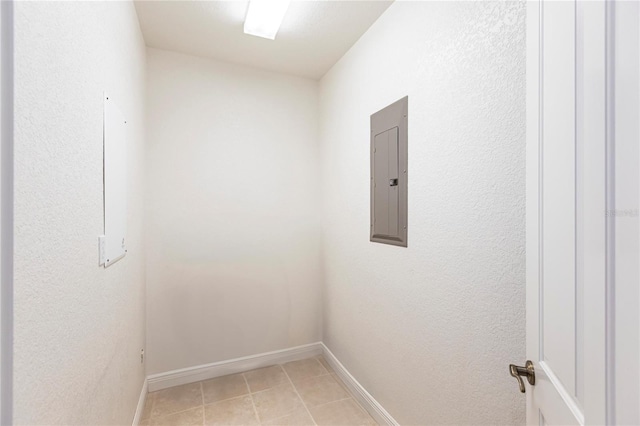 empty room with electric panel and light tile patterned flooring