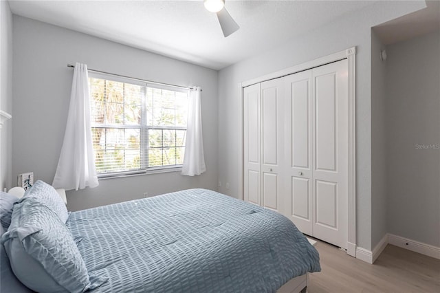 bedroom featuring light hardwood / wood-style flooring, ceiling fan, and a closet