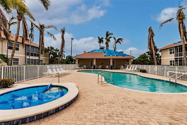 view of swimming pool featuring a jacuzzi and a patio area