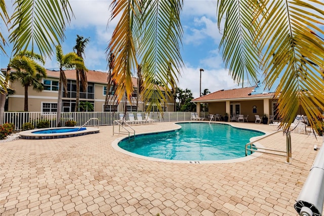 view of pool featuring a hot tub and a patio area