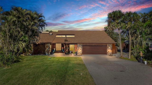 view of front of house featuring a garage and a lawn