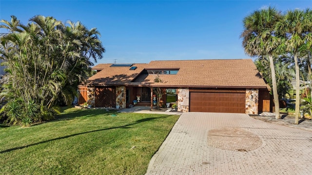 view of front facade featuring a garage, a front lawn, and solar panels