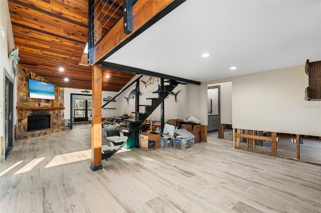 basement with a stone fireplace and light hardwood / wood-style floors