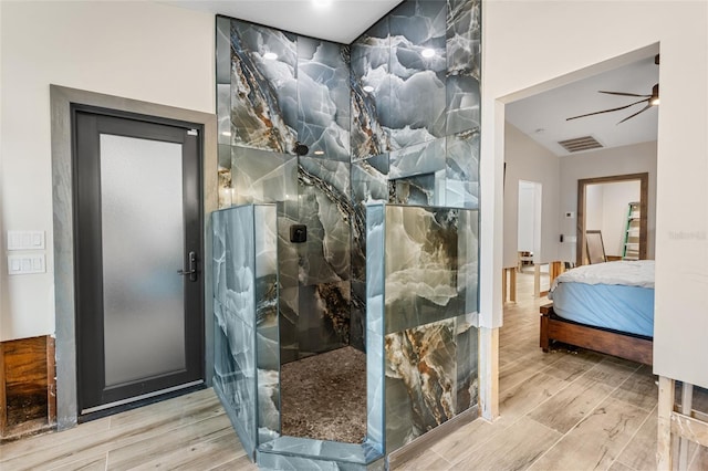 bathroom featuring hardwood / wood-style flooring, ceiling fan, vaulted ceiling, and a shower