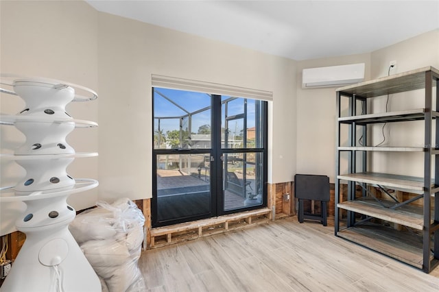 interior space with a wall unit AC and light hardwood / wood-style flooring