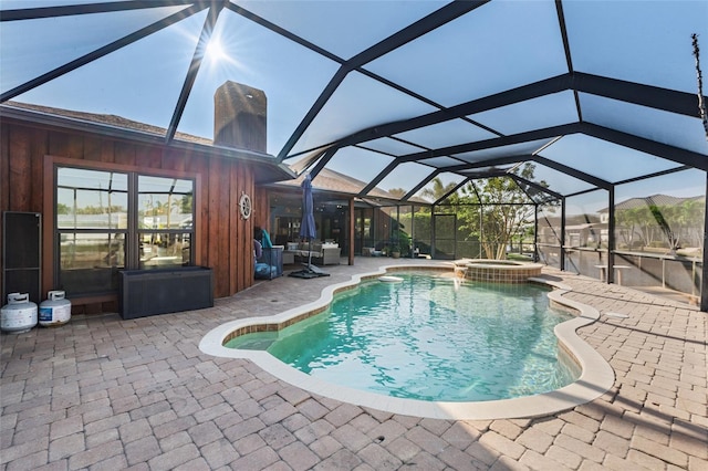 view of pool featuring an in ground hot tub, a patio, and glass enclosure