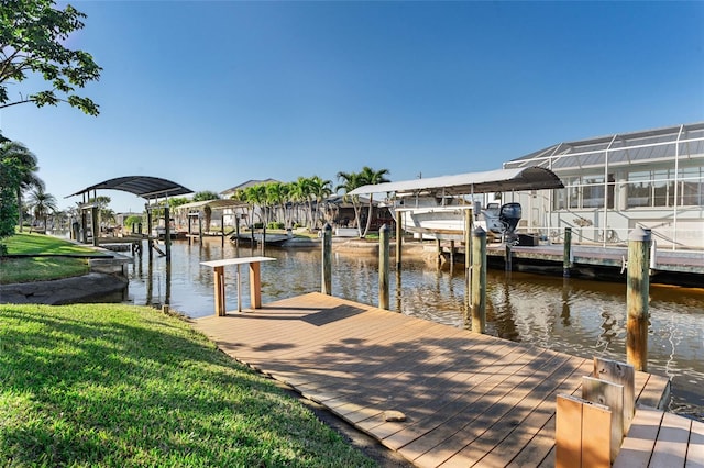 view of dock featuring a lanai, a water view, and a lawn