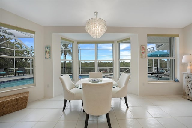 tiled dining space with a healthy amount of sunlight and a chandelier