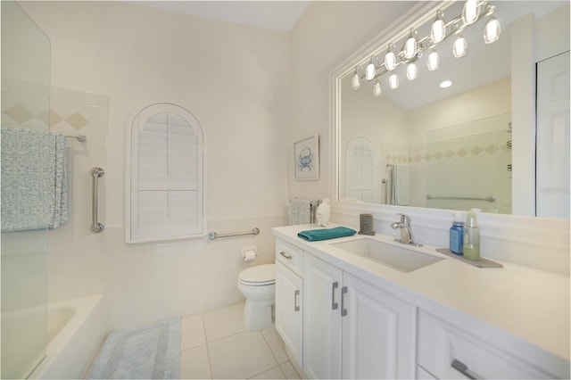 bathroom featuring tile walls, vanity, tile patterned floors, and toilet